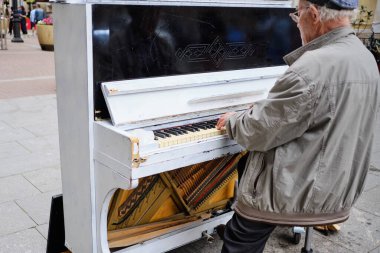 RUSSIA, ST.PETERSBURG - 20 Temmuz 2020: Piyano çalan yaşlı bir adam