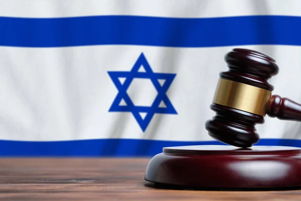 Justice and court concept in State of Israel. Judge hammer on a flag background.