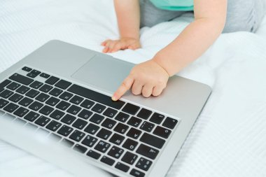 Bebek orada oturup parmağıyla klavyeye basıyor.