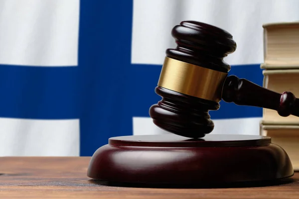 Justice and court concept in Republic of Finland. Judge hammer on a flag background.