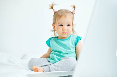 Kafkas çocuk yatakta oturup dizüstü bilgisayara bakıyor..