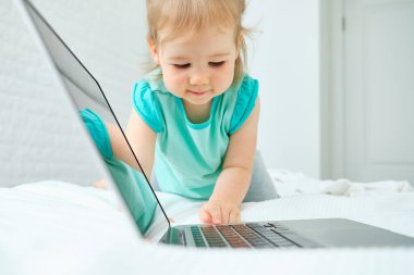 Kafkas çocuk yatakta oturur ve dizüstü bilgisayarın düğmesine basar..