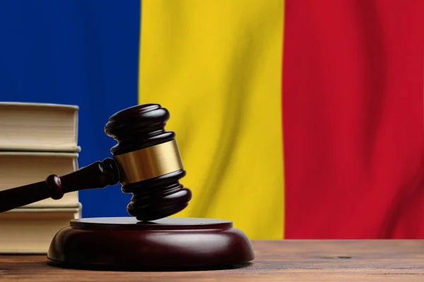 Justice and court concept in Romania. Judge hammer on a flag background.