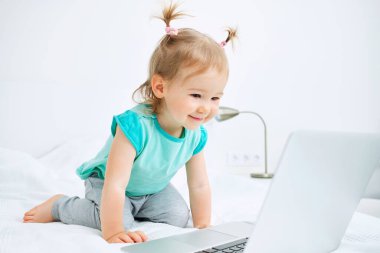 Kafkas çocuk yatakta oturup dizüstü bilgisayarında çizgi film izliyor..