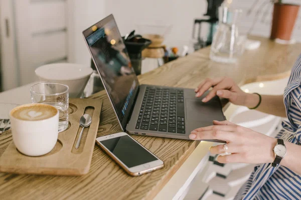 Dizüstü bilgisayar, telefon, kahve ve kızlar eller. Işık caffee çalışmak