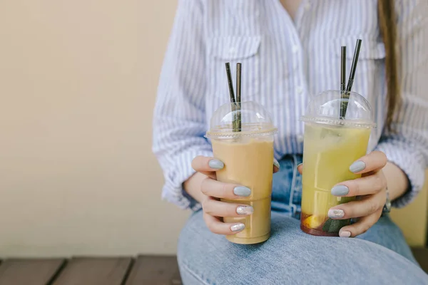 Dieta. Alimentação saudável. Mulher de camisa azul está entregando segurando bebidas de limonada no fundo bege natureza ao ar livre. Sumo de legumes de desintoxicação fresco. Estilo de vida saudável, comida vegetariana. Conceito nutricional . — Fotografia de Stock