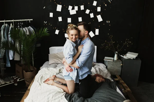 Gelukkig ochtend van jonge romantische verliefde paar veel plezier, kussen en knuffels in de slaapkamer. Liefde en relaties lifestyle, interieur zwart loft slaapkamer. — Stockfoto