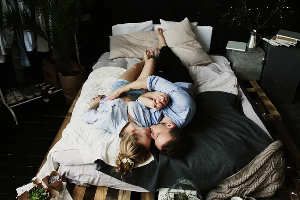 Aşık genç romantik çiftin mutlu sabah var eğlenceli, Öpüşme ve hugs yatak odasında. Aşk ve ilişkiler yaşam tarzı, iç siyah çatı katı yatak odası.