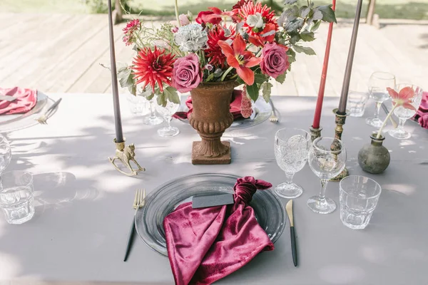 Banquete rústico, velas, óculos, flores vermelhas e rosa. A elegância e a luz estão ao redor. Preparação do casamento — Fotografia de Stock