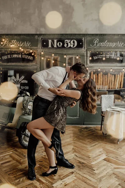 Doux couple est sur le fond de café français dansent. La fille est en robe à paillettes. Lumières. Le style. L'amour — Photo