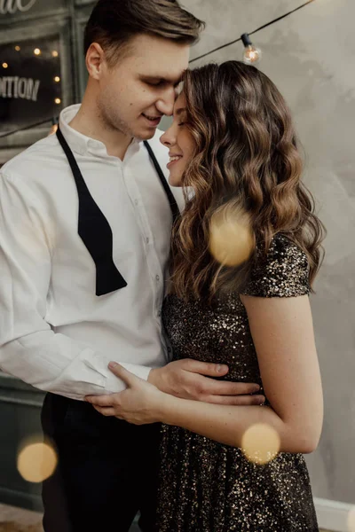 Sweet couple is on the french cafe background. They look to each other. Girl is in glitter dress. Lights. Style. Love — Stock Fotó