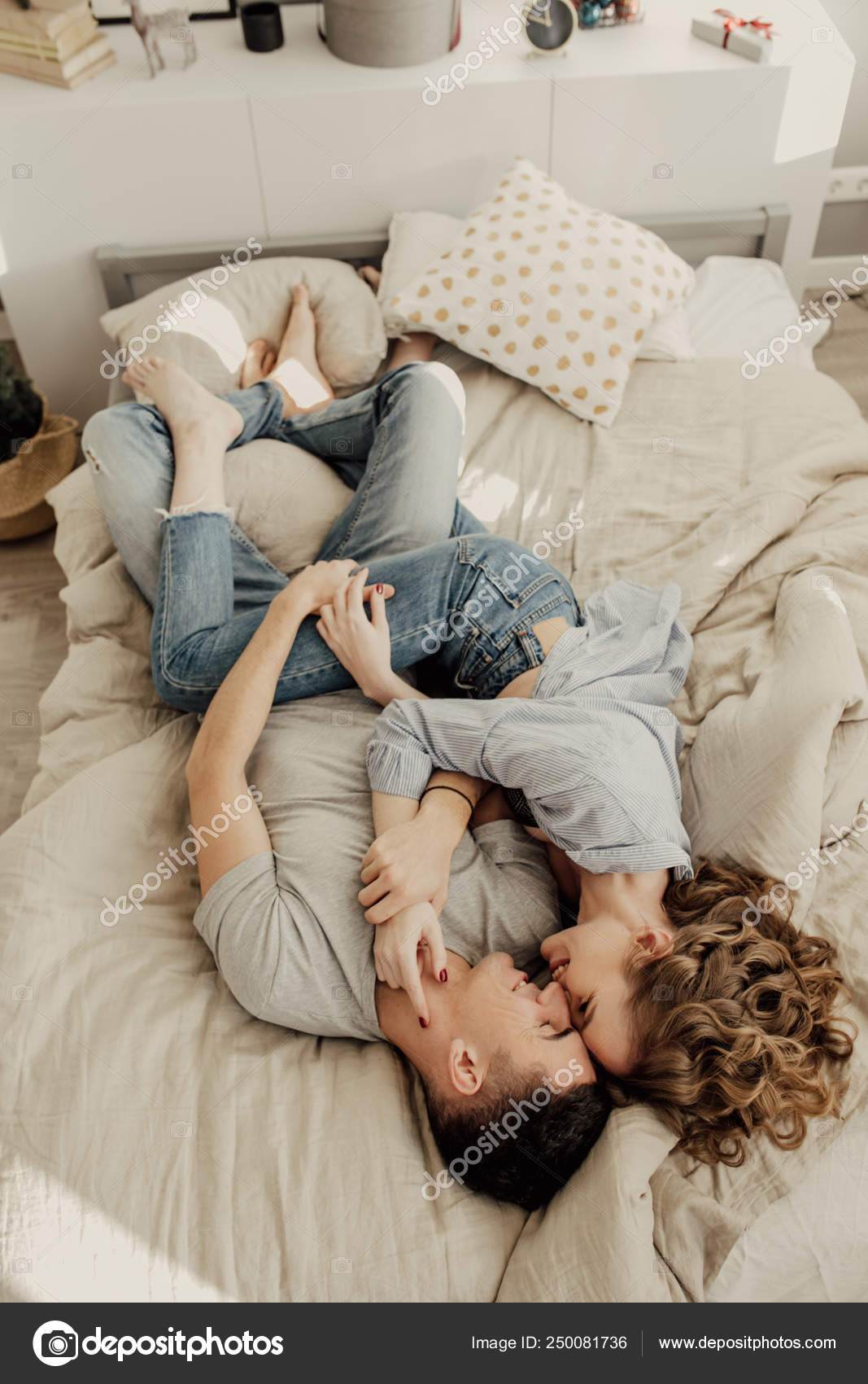Image of cute young couple in love lying on bed. kissing and hugs ...