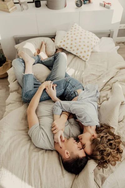 침대에 누워 사랑에 귀여운 젊은 커플의 이미지. 키스 하 고 침실에서 안 아. 사랑과 관계 라이프 스타일, 인테리어 로프트 침실. — 스톡 사진