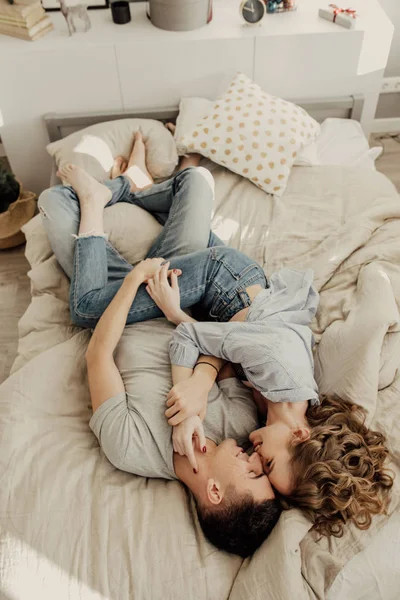 Image de mignon jeune couple amoureux couché sur le lit. baisers et câlins dans la chambre. Amour et relations style de vie, chambre loft intérieur . — Photo