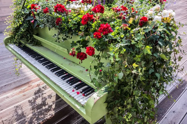 Ein Mit Blumen Bepflanztes Klavier Steht Draußen Auf Einem Holzboden — Stockfoto