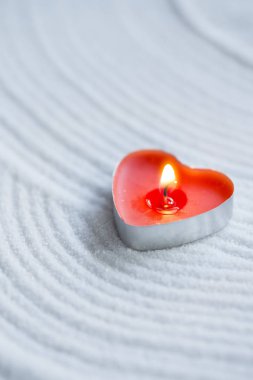 Beyaz kum üzerinde kırmızı mum