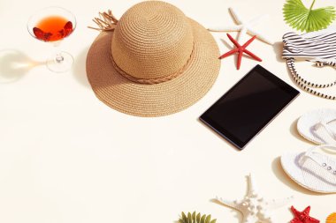 Kadının plaj aksesuarları ile siyah bir tablet