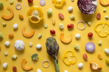 Sarı zemin üzerine taze dilimlenmiş sebze