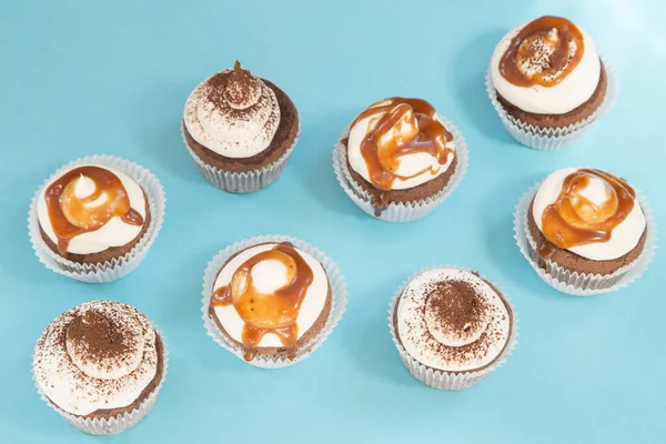 Caramel and chocolate cupcakes on blue background