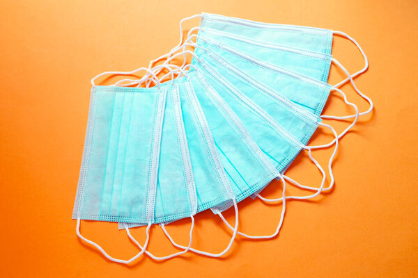 Protective face masks on orange background
