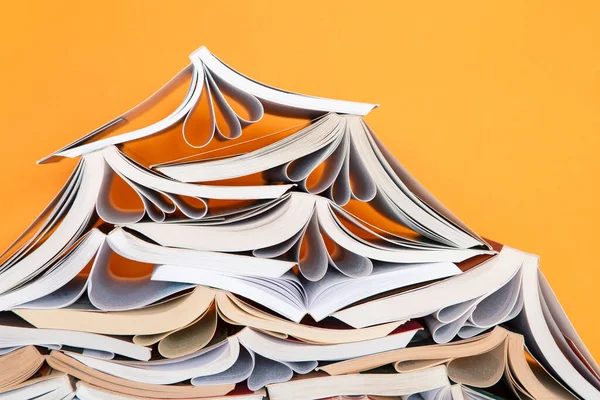 Pile of books over yellow background