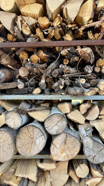 Kış için odun hazırlıyorum. Yakacak odun yığını manzarası. Kesilmiş odun kaotik bir şekilde yığının içine konur. Hazırlandı ve odun yığıldı