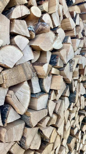 Kış için odun hazırlıyorum. Yakacak odun yığını manzarası. Kesilmiş odun kaotik bir şekilde yığının içine konur. Hazırlandı ve odun yığıldı