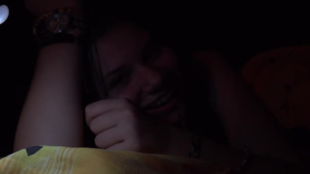 思春期の魅力的なスマート フォンを使用し 夜にベッドに横たわってリラックスし — ストック動画