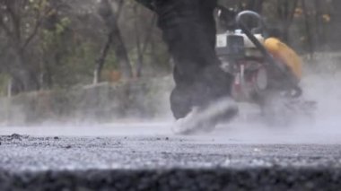İşçilerin sıcak asfalt bir sokak yol inşaat işçileri ile kürek koruyucu üniformalı koyarsın. Sıcak günde çalışma.