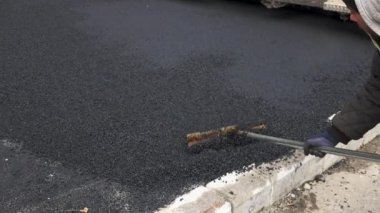İşçilerin sıcak asfalt bir sokak yol inşaat işçileri ile kürek koruyucu üniformalı koyarsın. Sıcak günde çalışma.