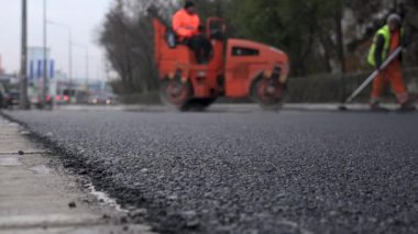 İşçilerin sıcak asfalt bir sokak yol inşaat işçileri ile kürek koruyucu üniformalı koyarsın. Sıcak günde çalışma.