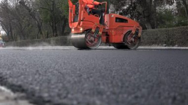 İşçilerin sıcak asfalt bir sokak yol inşaat işçileri ile kürek koruyucu üniformalı koyarsın. Sıcak günde çalışma.