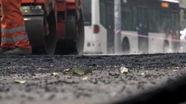 İşçilerin sıcak asfalt bir sokak yol inşaat işçileri ile kürek koruyucu üniformalı koyarsın. Sıcak günde çalışma.