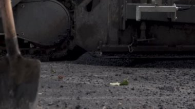 İşçilerin sıcak asfalt bir sokak yol inşaat işçileri ile kürek koruyucu üniformalı koyarsın. Sıcak günde çalışma.