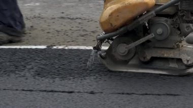İşçilerin sıcak asfalt bir sokak yol inşaat işçileri ile kürek koruyucu üniformalı koyarsın. Sıcak günde çalışma.