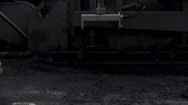 İşçilerin sıcak asfalt bir sokak yol inşaat işçileri ile kürek koruyucu üniformalı koyarsın. Sıcak günde çalışma.