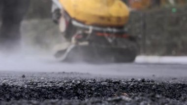 İşçilerin sıcak asfalt bir sokak yol inşaat işçileri ile kürek koruyucu üniformalı koyarsın. Sıcak günde çalışma.