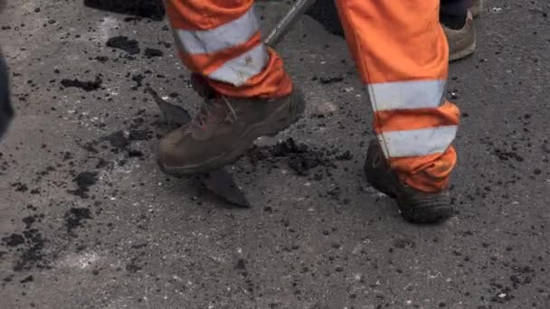 工人团队用铲子穿防护服 把热沥青放在街道路上的建筑工人身上 在炎热的天气里工作 — 图库视频影像