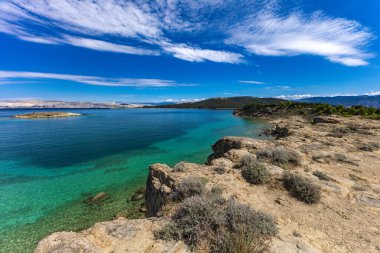 Adriyatik Denizi 'ndeki gök mavisi sular, Rab adasının kayalık kıyıları, bulutlu, tehditkar gökyüzü, adanın manzarası, Strucic beac