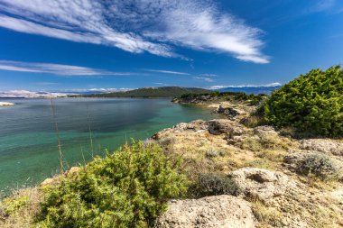 Adriyatik Denizi 'ndeki gök mavisi sular, Rab adasının kayalık kıyıları, bulutlu, tehditkar gökyüzü, adanın manzarası, Strucic plajı