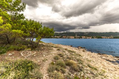 Koydan Rab kasabası manzarası, dört kule, kilise kulesi ve çan kulesi, bulutlu gökyüzü Hırvatistan