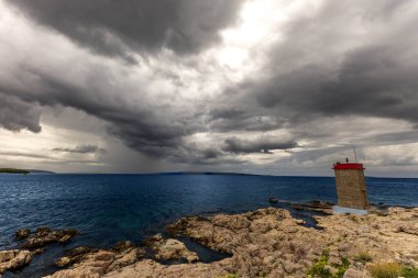 Koydan Rab kasabası manzarası, dört kule, kilise kulesi ve çan kulesi, bulutlu gökyüzü Hırvatistan