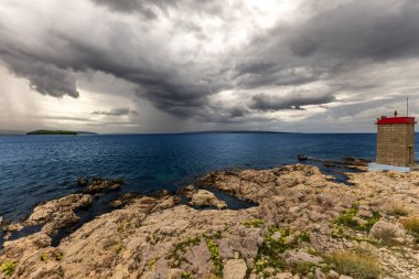 Koydan Rab kasabası manzarası, dört kule, kilise kulesi ve çan kulesi, bulutlu gökyüzü Hırvatistan