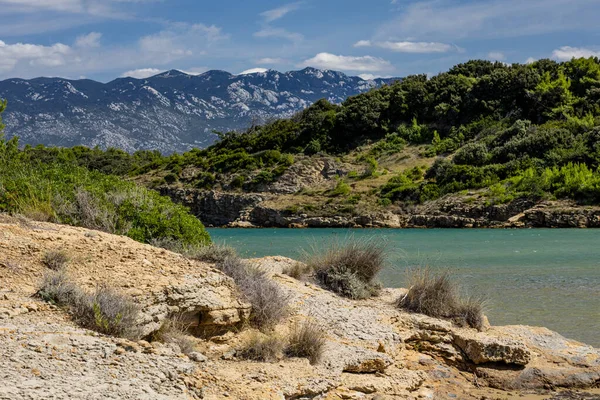 Adriyatik Denizi 'ndeki gök mavisi sular, Rab adasının kayalık kıyıları, bulutlu, tehditkar gökyüzü, adanın manzarası, Strucic plajı