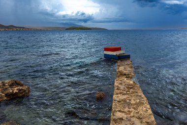 Koydan Rab kasabası manzarası, dört kule, kilise kulesi ve çan kulesi, bulutlu gökyüzü Hırvatistan