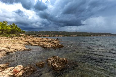 Koydan Rab kasabası manzarası, dört kule, kilise kulesi ve çan kulesi, bulutlu gökyüzü Hırvatistan