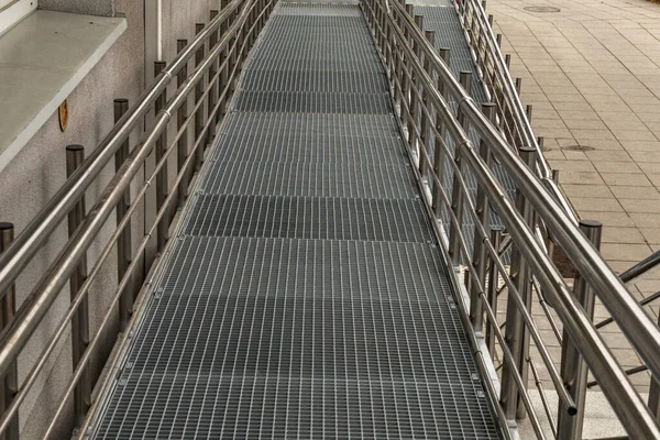 Engelliler için erişilebilir rampa, bebek arabaları ve engelliler için raylı metal rampa, kamu binasının mimari erişilebilirliği