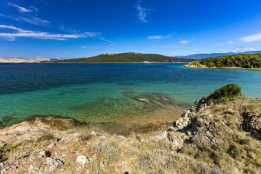 Sandy Sahara Sahili, Rab adasındaki en güzel FKK plajı, natürist plajı, mavi su ve bulutsuz gökyüzü.,