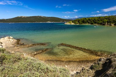 Sandy Sahara Sahili, Rab adasındaki en güzel FKK plajı, natürist plajı, mavi su ve bulutsuz gökyüzü.,