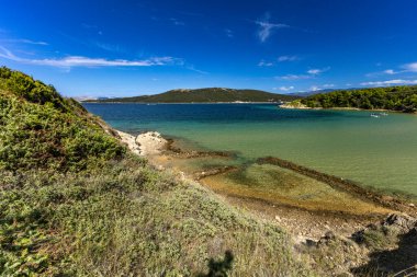 Sandy Sahara Sahili, Rab adasındaki en güzel FKK plajı, natürist plajı, mavi su ve bulutsuz gökyüzü.,